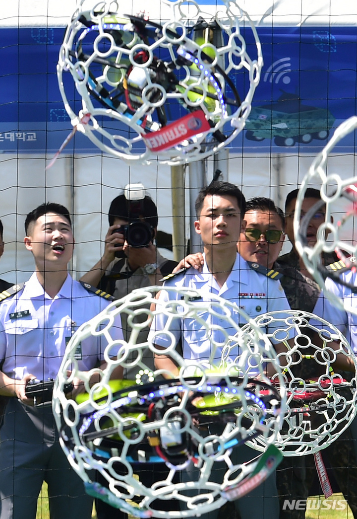 [대구=뉴시스] 이무열 기자 = 25일 오전 대구 육군 제2작전사 대연병장에서 열린 ‘제1회 2작전사령관배 드론봇 전투경연대회’에서 드론 축구에 참가한 육군 3사관학교 생도들이 공중에 매달린 둥근 골대에 드론을 넣기 위해 컨트롤에 집중하고 있다. 2023.05.25. lmy@newsis.com