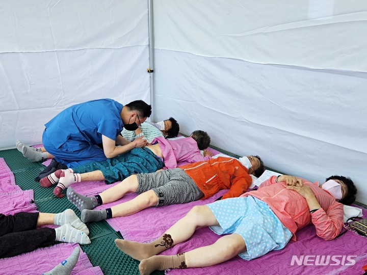 [서울=뉴시스]강인 창원자생한방병원 원장이 한산도 고령 주민들에게 침치료를 하고 있다. (사진= 창원자생한방병원 제공) 2023.05.26. photo@newsis.com. 