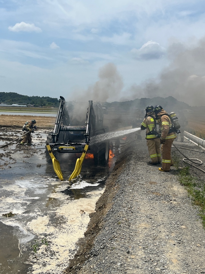 [군산=뉴시스] 최정규 기자 = 군산시 개정면의 한 논에서 작업 중이던 트랙터에서 불이나 소방관들이 진화 중이다.(전북소방본부 제공) 2023.05.26. *재판매 및 DB 금지