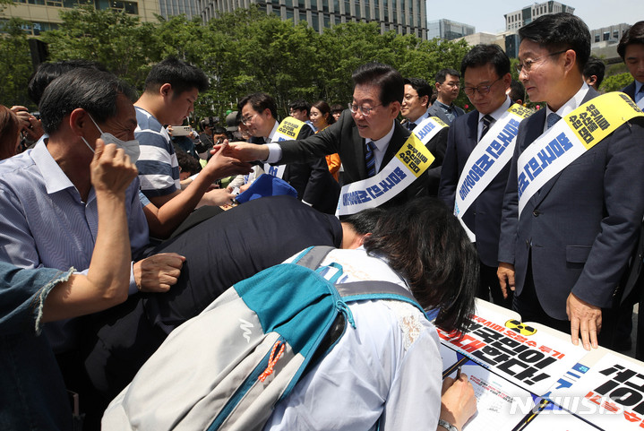 [서울=뉴시스] 조수정 기자 = 더불어민주당 이재명 대표가 26일 오전 서울 광화문광장에서 후쿠시마 원전 오염수 해양 투기 및 수산물 수입 반대 서명운동 발대식을 마친 뒤 시민들의 서명을 받던 중 지지자와 악수하고 있다. 2023.05.26. chocrystal@newsis.com