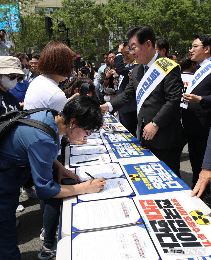 [서울=뉴시스] 조수정 기자 = 더불어민주당 이재명 대표와 박광온 원내대표, 의원들이 26일 오전 서울 광화문광장에서 후쿠시마 원전 오염수 해양 투기 및 수산물 수입 반대 서명운동 발대식을 마친 뒤 시민들의 서명을 받던 중 지지자와 악수하고 있다. 2023.05.26. chocrystal@newsis.com