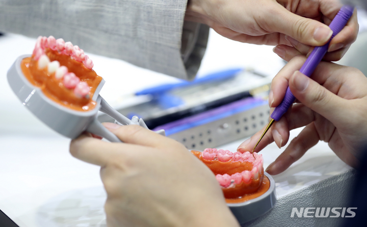 [서울=뉴시스] 최진석 기자 = 지난 5월 26일 서울 강남구 코엑스에서 열린 제20회 서울국제치과기자재전시회에서 관람객이 치위생기구 체험을 하고 있다. (해당 사진은 기사와 직접 관련이 없습니다.) 2023.05.26. myjs@newsis.com