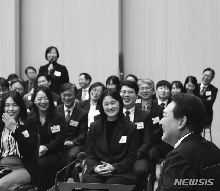 [서울=뉴시스]대통령실은 27일 윤석열 정부 출범 1주년을 기념해 '국민과 함께 시작한 여정'이라는 제목이 사진집을 냈다. 사진집 표지는 윤 대통령이 MZ공무원들과 환한 웃음을 짓는 모습으로 장식했다. 대통령실 제공