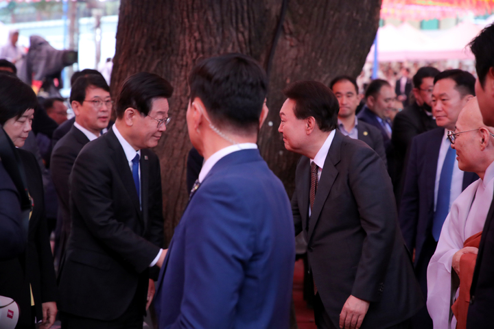 [서울=뉴시스] 홍효식 기자 = 윤석열 대통령과 이재명 더불어민주당 대표가 27일 서울 종로구 조계사에서 열린 불기 2567년 '부처님오신날' 봉축법요식에서 악수를 하고 있다. 2023.05.27. yesphoto@newsis.com