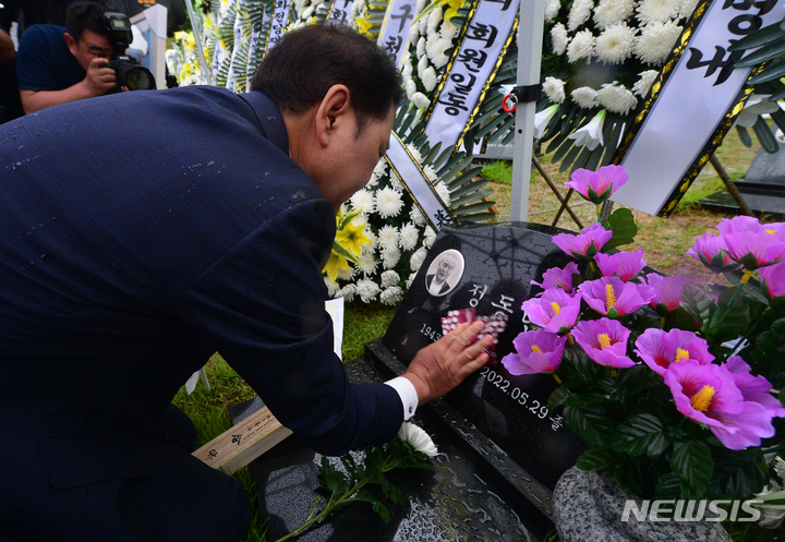 [광주=뉴시스] 김혜인 기자 = 29일 오전 광주 북구 운정동 국립 5·18민주묘지 2묘역에서 열린 '고 정동년 선생 1주기 추모제' 에서 재송정동년선생기념사업회 준비위원장이 묘비를 닦고 있다. 2023.05.29. hyein0342@newsis.com