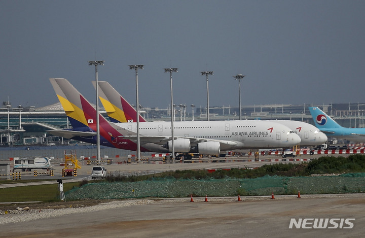 [인천공항=뉴시스] 정병혁 기자 = 29일 인천국제공항 주기장에 아시아나항공 여객기가 주기되어 있다. 아시아나항공 조종사노동조합이 사측과의 임금 협상에서 입장차를 좁히지 못하고 본격적으로 쟁의행위를 시작한다. 조종사노조는 쟁의행위 찬반 투표 결과 찬성률(92.39%)을 기록함에 따라 다음 달 7일부터 합법적인 방식으로 비행기를 지연시키는 준법투쟁 등의 방식으로 쟁의를 시작할 예정이다. 2023.05.29. jhope@newsis.com