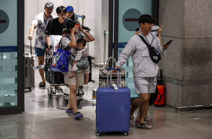 [인천공항=뉴시스] 정병혁 기자 = 29일 오후 인천국제공항 제1여객터미널 입국장에서 태풍 '마와르' 여파로 폐쇄됐던 괌 국제공항에 발 묶였던 여행객들이 귀국하고 있다. 2023.05.29. jhope@newsis.com