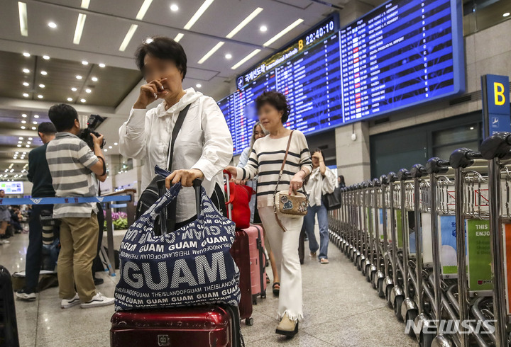 [인천공항=뉴시스] 정병혁 기자 = 29일 오후 인천국제공항 제1여객터미널 입국장에서 태풍 '마와르' 여파로 폐쇄됐던 괌 국제공항에 발 묶였던 여행객들이 귀국하고 있다. 2023.05.29. jhope@newsis.com