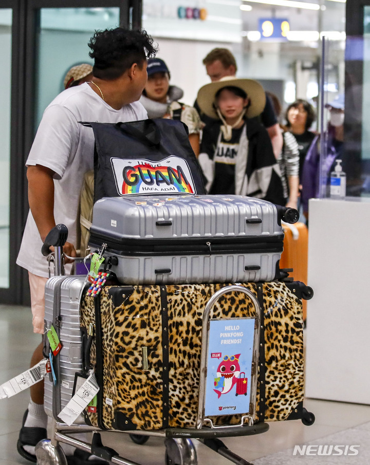 [인천공항=뉴시스] 정병혁 기자 = 29일 오후 인천국제공항 제1여객터미널 입국장에서 태풍 '마와르' 여파로 폐쇄됐던 괌 국제공항에 발 묶였던 여행객들이 귀국하고 있다. 2023.05.29. jhope@newsis.com
