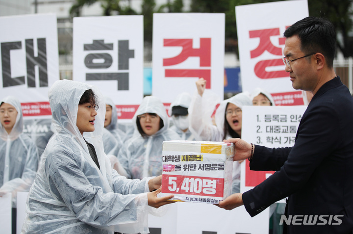 [서울=뉴시스] 김진아 기자 = 전국대학학생회네트워크가 28일 서울 용산구 대통령 집무실 앞에서 열린 '2023 대학생 3대 문제 해결을 위한 공동행동 : 등록금·생활비·구조조정, 대학생 재정난 해결을 위한 서명 전달 기자회견'에서 서명서를 대통령실 관계자에게 전달하고 있다. 2023.05.28. bluesoda@newsis.com