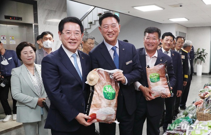 [장성=뉴시스] 이창우 기자=김영록 전남도지사(앞줄 왼쪽)와 김한종 장성군수가 30일 오후 장성군청 아카데미홀에서 열린 장성군민과 함께하는 '2023 도민과의 대화'에서 장성군 농특산물을 들고 기념촬영을 하고 있다. (사진=장성군 제공) 2023.05.30. photo@newsis.com *재판매 및 DB 금지