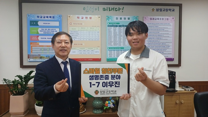 [수원=뉴시스] 김재철 삼일고 교장이 이우진군에게 '스마일 칭찬쿠폰 생명존중 분야' 쿠폰을 전달하고 있다. (사진=삼일고등학교 제공)2023.5.31. photo@newsis.com *재판매 및 DB 금지