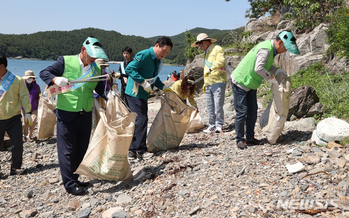 [고성=뉴시스] 홍정명 기자=박완수(가운데) 경남도지사가 31일 바다의 날을 맞아 고성군 삼산면 포교항 인근 해변에서 어촌인, 자원봉사자들과 쓰레기를 수거하고 있다.(사진=경남도 제공) 2023.05.31. photo@newsis.com