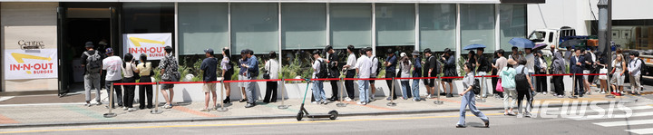 [서울=뉴시스] 권창회 기자 = 31일 오전 서울 강남구 인앤아웃 팝업스토어에서 시민들이 버거를 맛보기 위해 길게 줄을 서있다. ‘미국 3대 버거’로 불리는 인앤아웃 버거는 오전 11시부터 오후 3시까지 4시간 동안만 팝업스토어를 열고 더블더블 버거, 애니멀 스타일 버거, 프로틴 스타일 버거 등 3종류를 선착순 한정 판매할 예정이다. 2023.05.31. kch0523@newsis.com