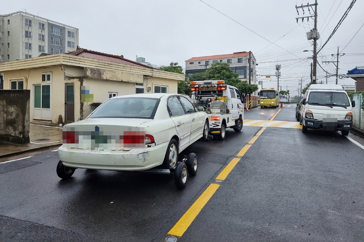 [제주=뉴시스] 제주시가 1일 공영주차장 내 방치 차량을 강제 견인하고 있다. (사진=제주시) 2023.06.01. photo@newsis.com *재판매 및 DB 금지