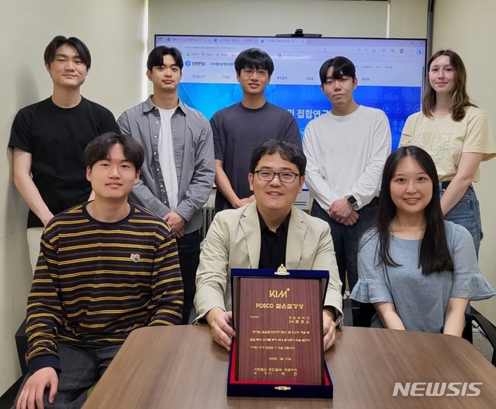 [창원=뉴시스] 홍정명 기자=창원대학교 신소재공학부 문준오(앞줄 가운데) 교수가 'POSCO 젊은철강상' 상패를 들고 구조재료설계 및 접합연구실 소속 학생들과 기념촬영하고 있다.(사진=창원대 제공) 2023.06.01. photo@newsis.com