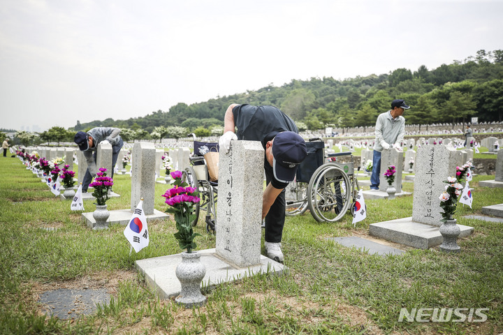 [서울=뉴시스] 정병혁 기자 = 1일 오전 서울 동작구 국립서울현충원에서 송파구 국가유공자들이 베트남 전쟁에 참전한 전우들의 묘역 정비를 하고 있다. 2023.06.01. jhope@newsis.com