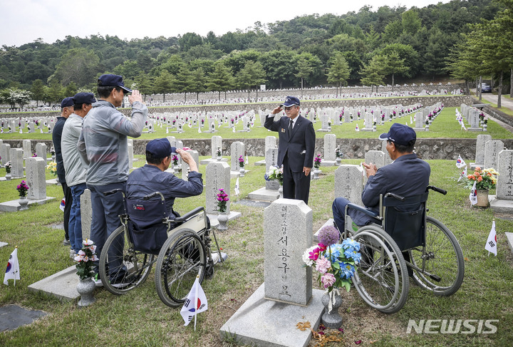 [서울=뉴시스] 정병혁 기자 = 1일 오전 서울 동작구 국립서울현충원에서 송파구 국가유공자들이 베트남 전쟁에 참전한 전우들의 묘역을 정비하기에 앞서 경례하고 있다. 2023.06.01. jhope@newsis.com
