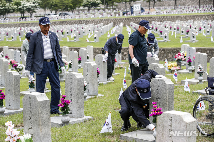 [서울=뉴시스] 정병혁 기자 = 1일 오전 서울 동작구 국립서울현충원에서 송파구 국가유공자들이 베트남 전쟁에 참전한 전우들의 묘역 정비를 하고 있다. 2023.06.01. jhope@newsis.com