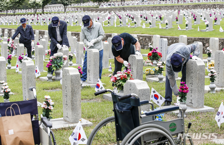 [서울=뉴시스] 정병혁 기자 = 1일 오전 서울 동작구 국립서울현충원에서 송파구 국가유공자들이 베트남 전쟁에 참전한 전우들의 묘역 정비를 하고 있다. 2023.06.01. jhope@newsis.com