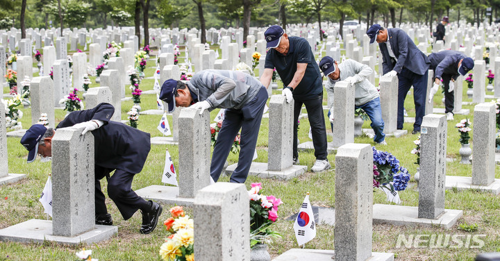 [서울=뉴시스] 정병혁 기자 = 1일 오전 서울 동작구 국립서울현충원에서 송파구 국가유공자들이 베트남 전쟁에 참전한 전우들의 묘역 정비를 하고 있다. 2023.06.01. jhope@newsis.com