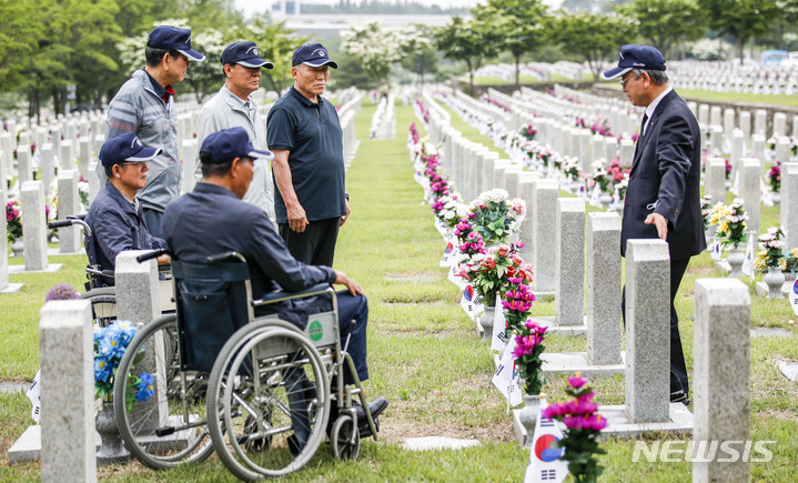 [서울=뉴시스] 정병혁 기자 = 1일 오전 서울 동작구 국립서울현충원에서 송파구 국가유공자들이 베트남 전쟁에 참전한 전우들의 묘역을 정비하기에 앞서 묘비를 바라보고 있다. 2023.06.01. jhope@newsis.com