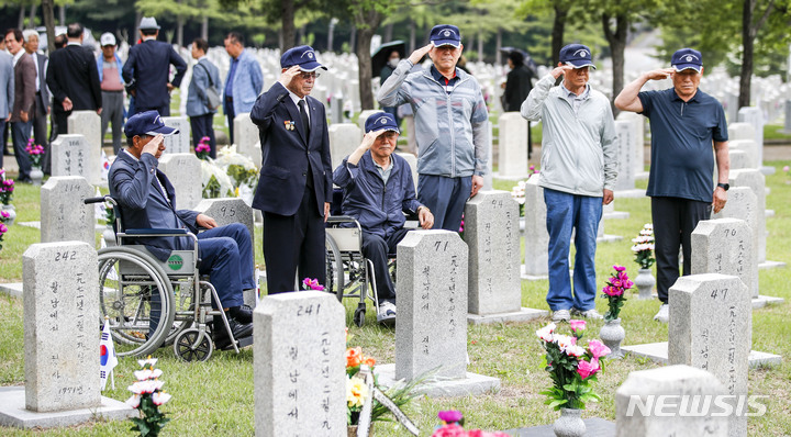 [서울=뉴시스] 정병혁 기자 = 1일 오전 서울 동작구 국립서울현충원에서 송파구 국가유공자들이 베트남 전쟁에 참전한 전우들의 묘역을 정비하기에 앞서 경례하고 있다. 2023.06.01. jhope@newsis.com