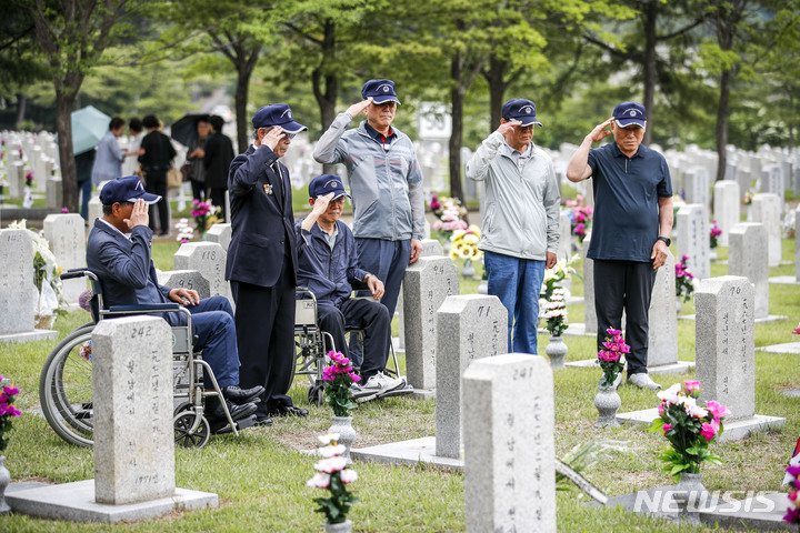 [서울=뉴시스] 정병혁 기자 = 1일 오전 서울 동작구 국립서울현충원에서 송파구 국가유공자들이 베트남 전쟁에 참전한 전우들의 묘역을 정비하기에 앞서 경례하고 있다. 2023.06.01. jhope@newsis.com