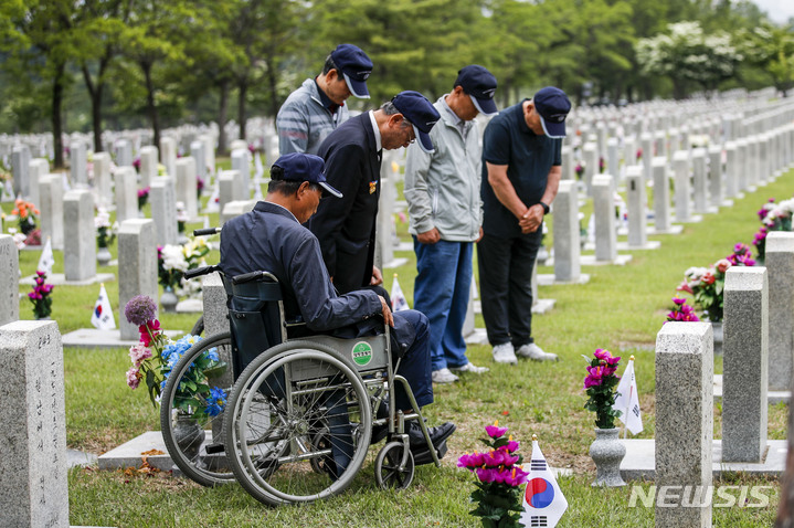 [서울=뉴시스] 정병혁 기자 = 1일 오전 서울 동작구 국립서울현충원에서 송파구 국가유공자들이 베트남 전쟁에 참전한 전우들의 묘역을 정비하기에 앞서 묵념을 하고 있다. 2023.06.01. jhope@newsis.com