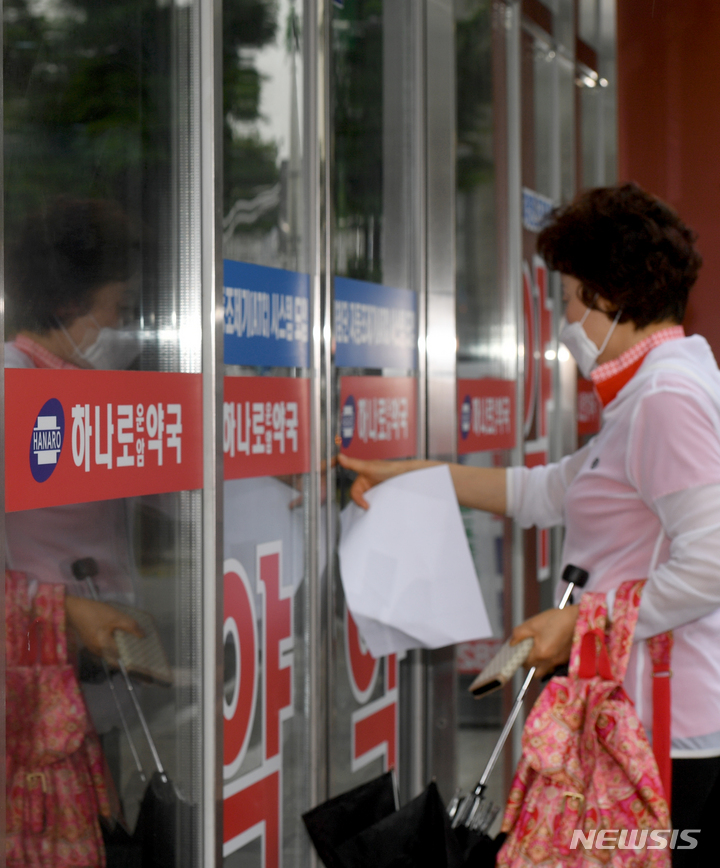 [광주=뉴시스] 변재훈 기자 = 코로나19 위기 경보가 '경계'로 완화된 첫날인 1일 오전 광주 북구 운암동 한 약국에 마스크를 쓴 시민이 들어가고 있다. '사실상 엔데믹'으로 접어든 이날부터 약국은 실내 마스크 착용 의무가 권고로 완화됐다. 2023.06.01. wisdom21@newsis.com