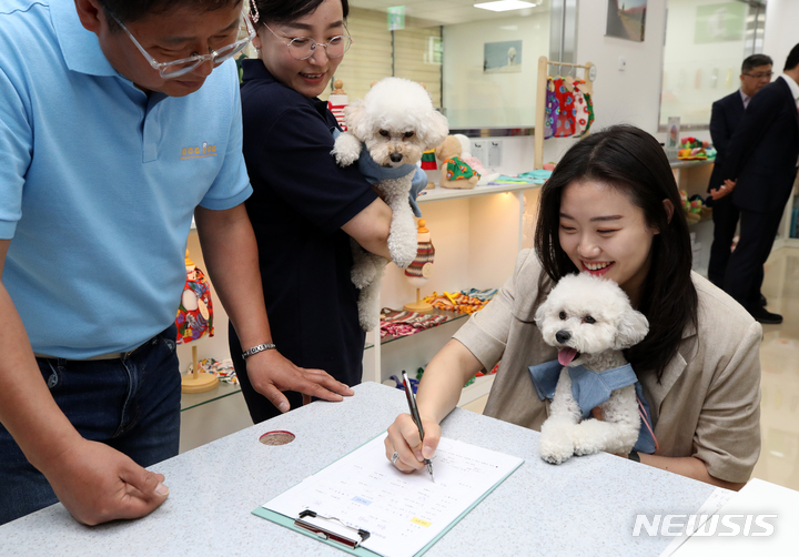 [서울=뉴시스] 조성우 기자 = 1일 오후 서울 강서구 김포공항 국내선 여객터미널에서 열린 애견센터 개소식에서 첫 이용객이 위탁 접수를 하고 있다. 2023.06.01. xconfind@newsis.com