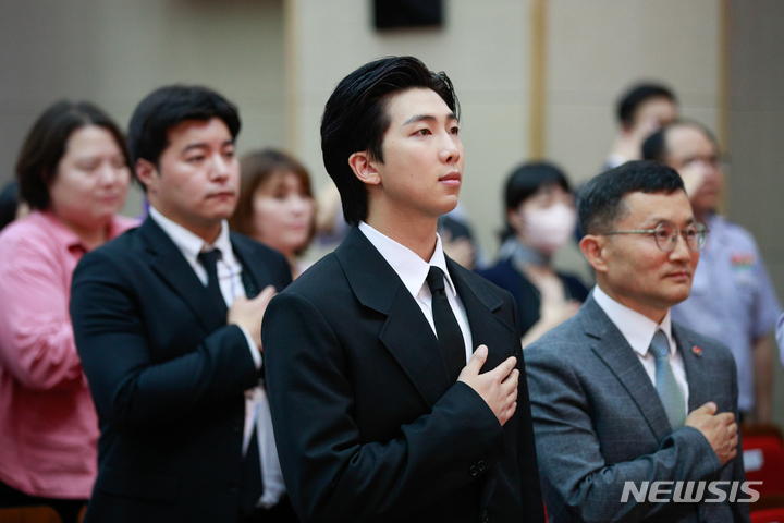 [서울=뉴시스] 사진공동취재단 = 방탄소년단(BTS)의 RM(김남준)이 1일 서울 동작구 국립서울현충원 현충관에서 열린 국방부 유해발굴감식단 홍보대사 위촉식에 참석해 이근원 단장과 국기에 대한 경례를 하고 있다. 2023.06.01. photo@newsis.com