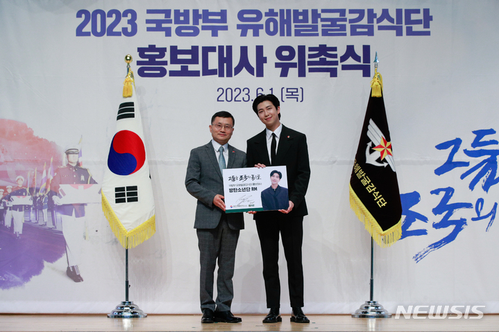 [서울=뉴시스] 사진공동취재단 = 방탄소년단(BTS)의 RM(김남준)이 1일 서울 동작구 국립서울현충원 현충관에서 열린 국방부 유해발굴감식단 홍보대사 위촉식에 참석해 이근원 단장으로부터 위촉패를 수여받은 뒤 기념 촬영하고 있다. 2023.06.01. photo@newsis.com