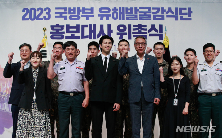 [서울=뉴시스] 사진공동취재단 = 방탄소년단(BTS)의 RM(김남준)이 1일 서울 동작구 국립서울현충원 현충관에서 열린 국방부 유해발굴감식단 홍보대사 위촉식에 참석해 직원들과 기념 촬영하고 있다. 2023.06.01. photo@newsis.com