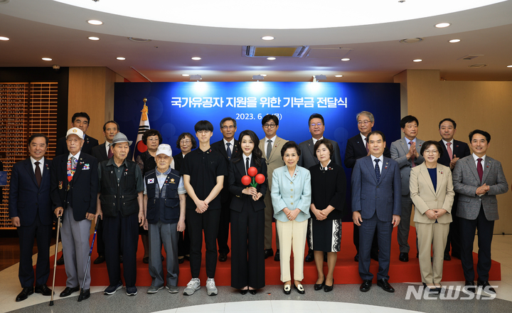 [서울=뉴시스] 윤석열 대통령 부인 김건희 여사가 1일 서울 중구 사랑의열매 회관에서 열린 국가유공자 지원을 위한 기부금 전달식에서 기부금을 전달한 뒤 기념촬영하고 있다. (사진=대통령실 제공) 2023.06.01. photo@newsis.com