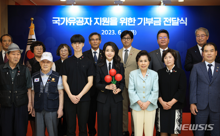 [서울=뉴시스] 윤석열 대통령 부인 김건희 여사가 1일 서울 중구 사랑의열매 회관에서 열린 국가유공자 지원을 위한 기부금 전달식에서 기부금을 전달한 뒤 기념촬영하고 있다. (사진=대통령실 제공) 2023.06.01. photo@newsis.com