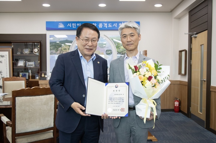 [익산=뉴시스] 강명수 기자 =2일 정헌율 전북 익산시장이 외국인의 지역사회 정착과 사회통합에 앞장선 공로를 인정받은 행정안전부 장관상을 받은 성요셉노동자의집에 이를 전수하며 김호철 사무국장과 기념촬영을 하고 있다. (사진 =익산시 제공) 2023.06.02. photo@newsis.com *재판매 및 DB 금지