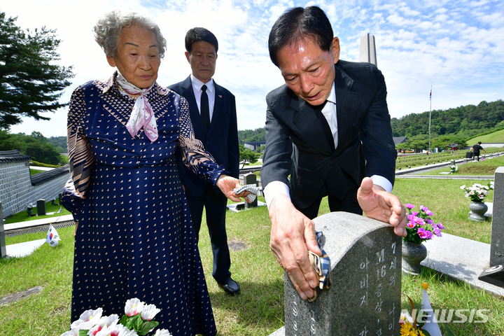 [광주=뉴시스] 이영주 기자 = 임성록 (사)대한민국 특전사동지회 고문(사진 오른쪽)과 5·18최초 희생자 고(故) 김경철 열사의 어머니 임근단 여사, 5·18 당시 시민군이었던 김태수씨가 4일 오전 광주 북구 운정동 국립5·18민주묘지 행방불명자묘역 내 이창현 군의 가묘를 찾아 묘비를 닦으며 참배하고 있다. 2023.06.04. leeyj2578@newsis.com