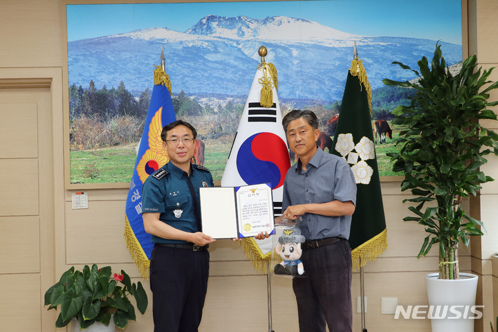 [제주=뉴시스] 오영재 기자 = 문영근 제주동부경찰서장(왼쪽)이 5일 경찰서 회의실에서 버스기사 이모씨에게 감사장을 전달하고 있다. (사진=제주동부경찰서 제공) 2023.06.05. photo@newsis.com