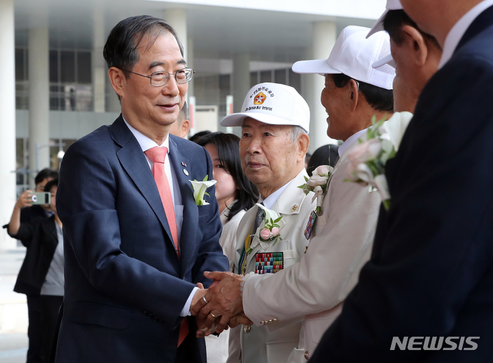 [세종=뉴시스] 강종민 기자 = 한덕수 국무총리가 5일 세종시 정부세종청사에서 열린 국가보훈부 현판식에서 국가유공자와 인사하고 있다. 국가보훈부는 1961년 군사원호청으로 출발한 지 62년 만에 이날 공식 출범했다. 국가보훈부는 1961년 군사원호청으로 출발한 지 62년 만에 이날 공식 출범했다. 2023.06.05. ppkjm@newsis.com