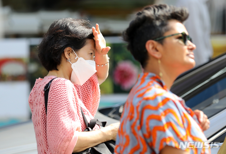 [서울=뉴시스] 김명년 기자 = 더운 날씨를 보인 5일 오후 서울 종로구 쌈지길에서 한 시민이 손으로 햇빛을 가린 채 이동하고 있다. 2023.06.05. kmn@newsis.com