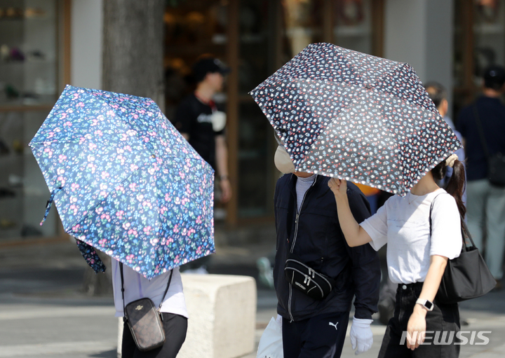 [서울=뉴시스] 김명년 기자 = 더운 날씨를 보인 5일 오후 서울 종로구 쌈지길에서 시민들이 양산으로 햇빛을 가린 채 이동하고 있다. 2023.06.05. kmn@newsis.com