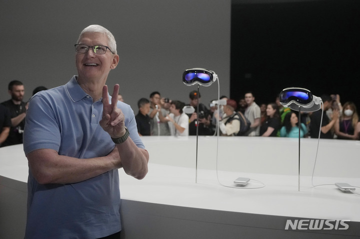 [쿠퍼티노=AP/뉴시스]팀 쿡 애플 CEO가 지난 5일(현지시간) 미국 캘리포니아 쿠퍼티노 애플 캠퍼스 에 전시된 '애플 비전 프로' 앞에서 포즈를 취하고 있다. 2023.6.5.