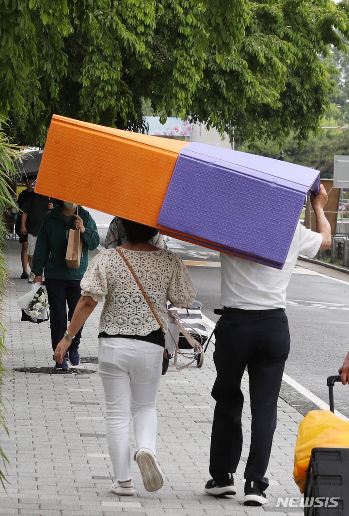 [서울=뉴시스] 조성봉 기자 = 현충일인 지난 6일 오후 서울 동작구 국립서울현충원에서 소나기가 내리자 시민들이 돗자리를 머리에 쓰고 비를 피하고 있다. 2023.06.06. suncho21@newsis.com