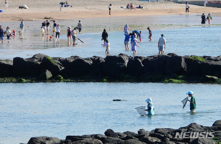 [제주=뉴시스] 우장호 기자 = 제주시 이호해수욕장을 찾은 도민과 나들이객들이 바닷물에 발을 담그며 즐거운 시간을 보내고 있다. 2023.06.06. woo1223@newsis.com