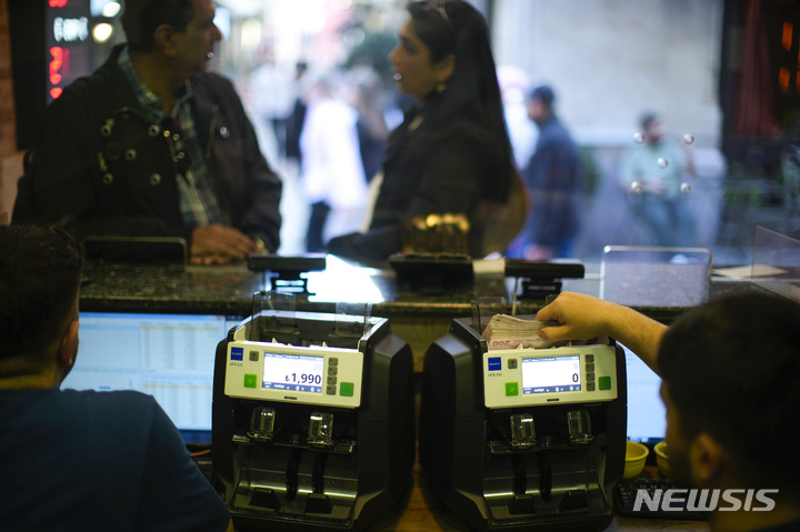 [이스탄불(튀르키예)=AP/뉴시스]지난 5월 2일 튀르키예 이스탄불의 한 환전소에서 직원이 튀르키예 리라화 지폐를 세고 있다. 튀르키예 리라화가 7일 레제프 타이이프 에르도안 대통령의 3번째 임기 시작 후 미 달러화에 대한 하락폭을 확대하면서 사상 최저치로 떨어졌다. 리라화는 이날 달러당 23.15리라를 기록, 6% 이상 하락했다. 이에 따라 리라화는 에르도안 대통령의 새 정부 임명 이후 가치 하락이 8%로 커졌으며 올해 들어서만 20% 가량 가치가 떨어졌다. 2023.06.07.