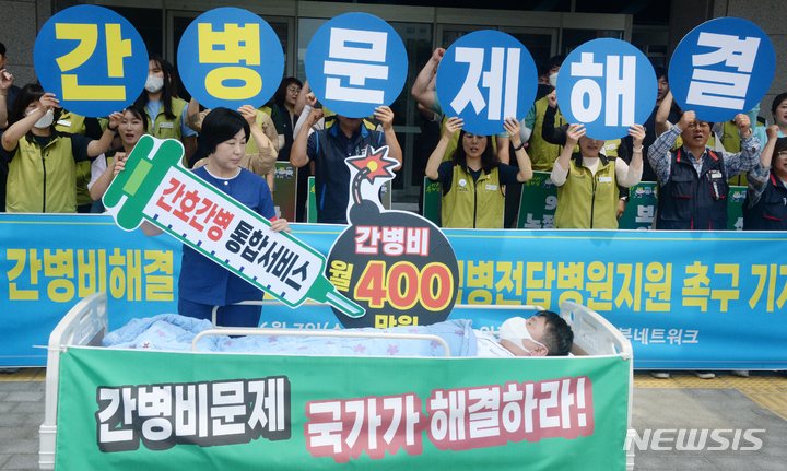 [전주=뉴시스] 김얼 기자 = 의료공공성강화전북네트워크와 전국보건의료산업노동조합전북지부 관계자들이 7일 전북 전주시 전북도청 앞에서 '간병비해결·불법의료해결·감염병전담병원지원 촉구 기자회견'을 열고 구호를 외치고 있다. 2023.06.07. pmkeul@nwsis.com