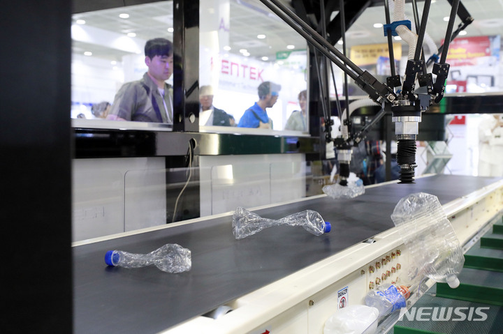 [서울=뉴시스] 최동준 기자 = 지난해 6월7일 서울 강남구 코엑스에서 열린 제44회 국제환경산업기술&그린에너지전을 찾은 시민들이 폐기물 분류 로봇을 살펴보고 있는 모습. 2023.06.07. photocdj@newsis.com