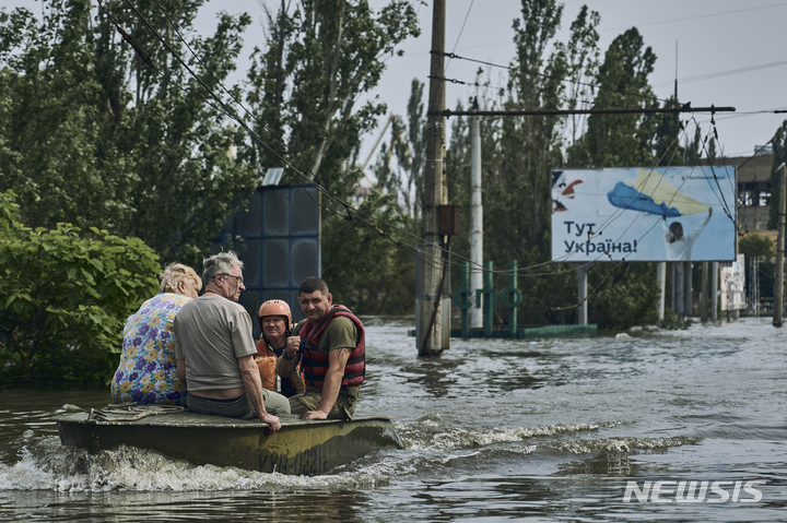 [AP/뉴시스] 파괴된 댐에서 남으로 70킬로미터 떨어진 헤르손시에서 7일 비상요원들이 주민들을 보트에 태우고 물이 가득들어찬 도시에서 소개하고 있다. 2023. 06. 08