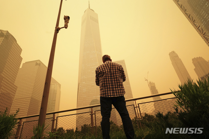 [뉴욕=AP/뉴시스] 7일(현지시간) 미국 매체 마켓워치 등은 캐나다 산불의 여파로 미국 뉴욕의 대기질이 극악의 상황에 처했다고 전했다. 사진은 미국 뉴욕 월드트레이드센터 앞에서 황회색으로 변한 하늘을 바라보는 한 행인. 2023.06.08.